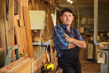 Üniformalı marangozun portresi marangozluk fabrikasında marangozluk yapıyor.