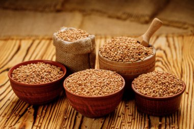 İnci arpa kaselerde homurdanır ve tahta bir arka planda torbalar. Yüksek kalite fotoğraf