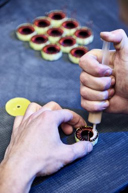 Uzman bilgisayar cihazları için elektromanyetik bobinler yapıyor.