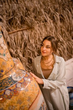 Al Seef yakınlarındaki Arap pazarında elinde çanak çömlek, lamba ve fenerlerle yürüyen kadın turist.