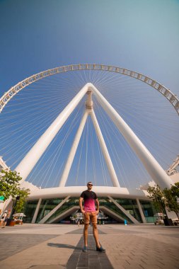 Dubai, BAE - Kasım 06, 2021: Erkek turist Ain (Eye) DUBAI 'yi ziyaret etti - Bluewater Adası' ndaki dünyanın en büyük dönme dolaplarından biri. Birleşik Arap Emirlikleri 'nin en iyi turistleri arasında