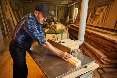 Üniformalı kıdemli marangoz marangozluk fabrikasında marangoz olarak çalışıyor.