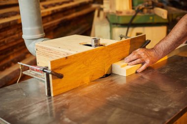 Üniformalı kıdemli marangoz marangozluk fabrikasında marangoz olarak çalışıyor.