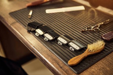 Berber aletleri alır. Berber dükkanında masayı kesmeye yarayan aksesuarlar. Tarak, fırça, makas, makas ve hortumlar.