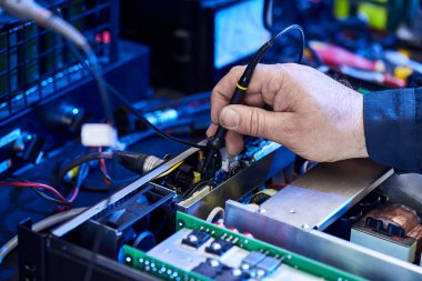 Donanım teçhizatı tamir ediliyor. Tamirci ve Aletli İşçi. Mikroçip ve devre kartı. Masada Modern Dijital Aygıt Denemesi. Elektronik Aygıtlar Konsepti.