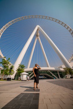 Ain (Eye) DUBAI 'yi ziyaret eden kadın turist, Bluewater Adası' ndaki dünyanın en büyük dönme dolaplarından birini ziyaret ediyor. Birleşik Arap Emirlikleri 'nin en iyi turistleri arasında