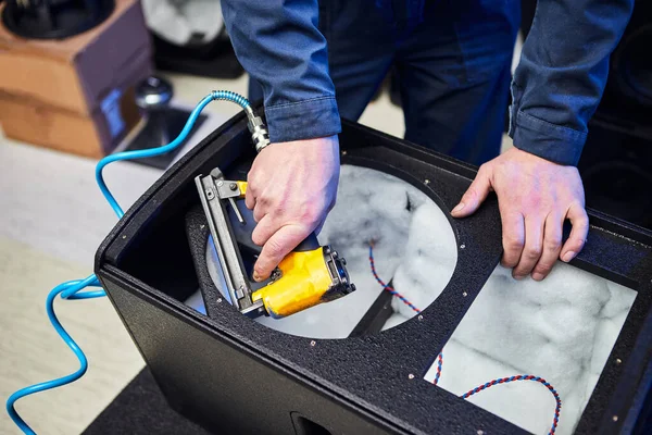 İşçi fabrikada hoparlör ve hoparlör üretiyor. El yapımı akustik müzik sistemleri