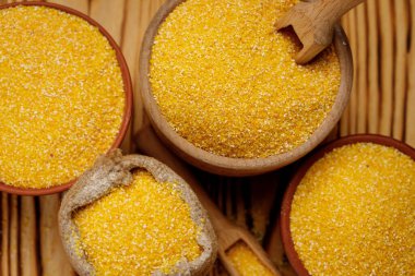 Mısır kaselerde inliyor ve tahta arka planda torbalar var. Yüksek kalite fotoğraf