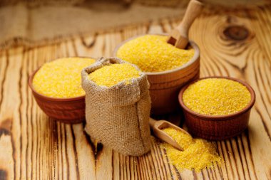 Mısır kaselerde inliyor ve tahta arka planda torbalar var. Yüksek kalite fotoğraf