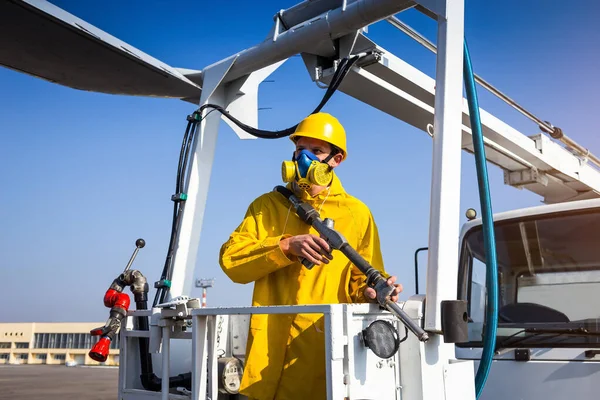 Uzman, havaalanında uçağı antifriz ile tedavi ediyor. Havaalanındaki bir uçak kanadında buz çözücü sıvı püskürtme işlemi.