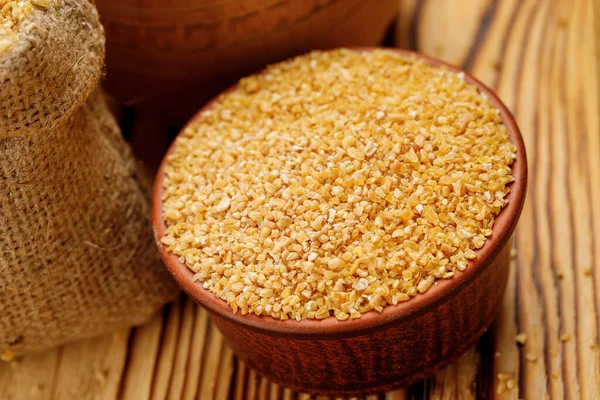 Buğday kaselerde büyür ve tahta bir arka planda torbalar. Yüksek kalite fotoğraf