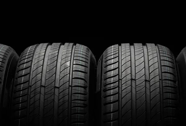 新车胎 黑暗背景下的一组公路车轮 夏天的疲劳与不对称的胎面设计 驾驶汽车的概念 — 图库照片