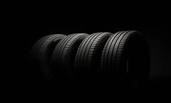 新车胎 黑暗背景下的一组公路车轮 夏天的疲劳与不对称的胎面设计 驾驶汽车的概念 — 图库照片