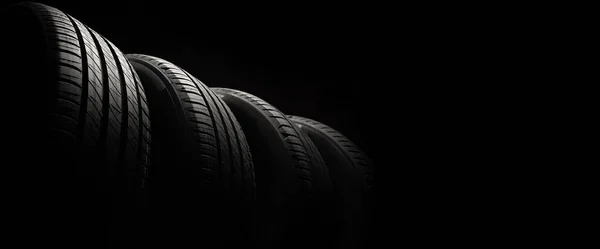 新しい車のタイヤ 暗い背景に道路の車輪のグループ 非対称トレッドデザインのサマータイヤ 運転車のコンセプト — ストック写真