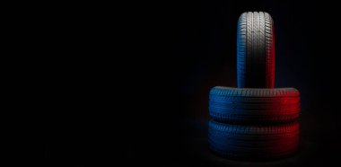 Yeni araba lastikleri. Karanlık arka planda bir grup yol tekeri. Asimetrik lastik dizaynlı yaz lastikleri. Araba sürme kavramı.