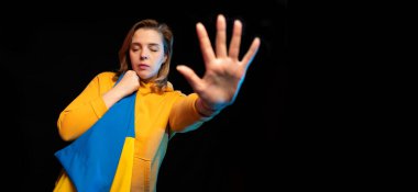 Ukrayna bayrağı siyah arka planda güzel bir Ukraynalı kız. Uzayı kopyala Rus Ukrayna Savaşı. Ukrayna için yardım ve dua et. Savaşı durdurun..