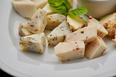 Peynir tabağı: parmesan, çedar, gouda, mozzarella ve diğer koyu arkaplanda beyaz tabakta bal. Lezzetli aperatifler. Üst Manzara. Restoran menüsü için fotoğraf