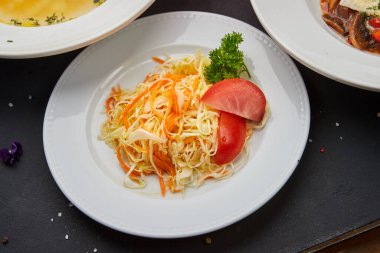 Çorba, lahana salatası, sebzeli tavuk ve komposto içeren iş yemeği menüsü.