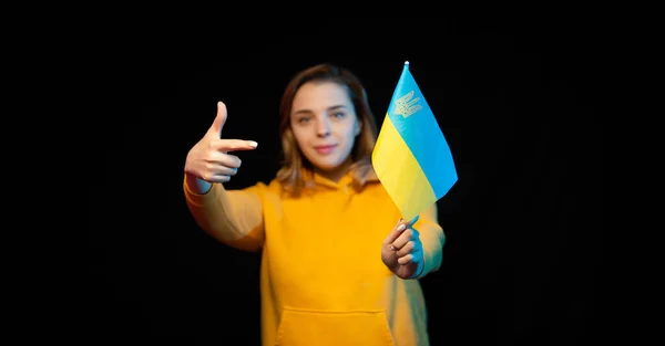 ウクライナ国旗 黒の背景に彼女の手の棒の上に政府の旗を持つ美しいウクライナの少女 ウクライナ国家のシンボル — ストック写真