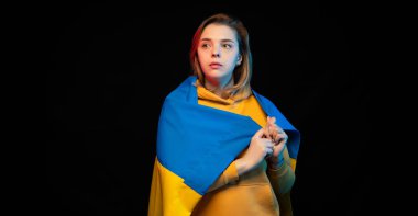 Ukrayna bayrağı siyah arka planda güzel bir Ukraynalı kız. Uzayı kopyala Rus Ukrayna Savaşı. Ukrayna için yardım ve dua et. Savaşı durdurun..