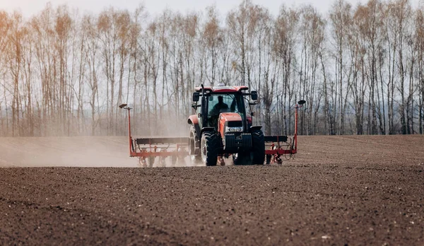 Bahar ekme mevsimi. Traktörlü bir çiftçi tarlasına mısır tohumu ekiyor. İzli ekiciyle mısır ekiyorum. Çiftçilik tohumları. Tarım ve tarım makineleri kavramı.