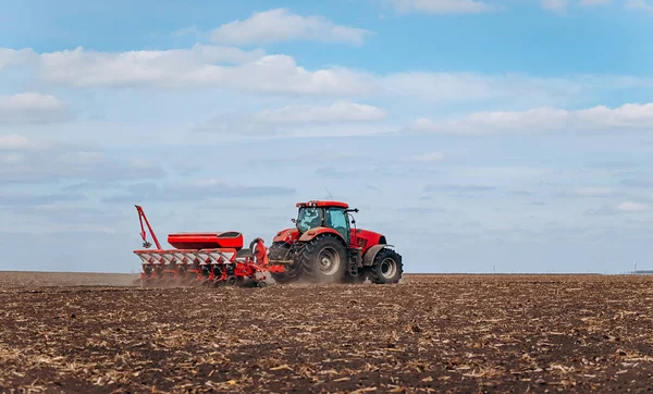 Bahar ekme mevsimi. Traktörlü bir çiftçi tarlasına mısır tohumu ekiyor. İzli ekiciyle mısır ekiyorum. Çiftçilik tohumları. Tarım ve tarım makineleri kavramı.