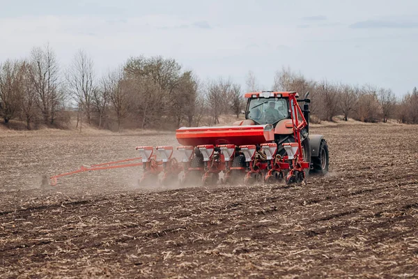 Bahar ekme mevsimi. Traktörlü bir çiftçi tarlasına mısır tohumu ekiyor. İzli ekiciyle mısır ekiyorum. Çiftçilik tohumları. Tarım ve tarım makineleri kavramı.