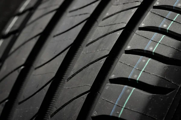 Yeni araba lastikleri. Karanlık arka planda bir grup yol tekeri. Asimetrik lastik dizaynlı yaz lastikleri. Araba sürme kavramı.