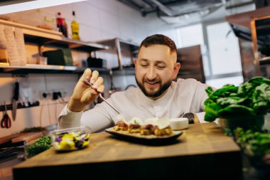 Şef aşçı lokanta misafirlerine servis edilmeden önce aperatifleri, kanepeleri ve sandviçleri servis ediyor.