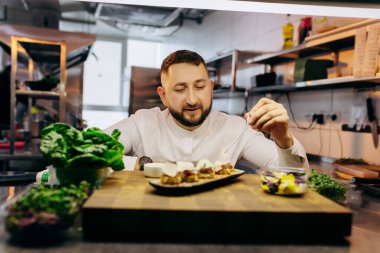 Şef aşçı lokanta misafirlerine servis edilmeden önce aperatifleri, kanepeleri ve sandviçleri servis ediyor.