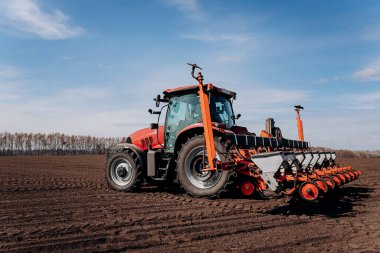 Bahar ekme mevsimi. Traktörlü bir çiftçi tarlasına mısır tohumu ekiyor. İzli ekiciyle mısır ekiyorum. Çiftçilik tohumları. Tarım ve tarım makineleri kavramı.