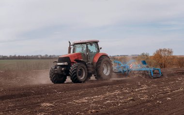 Bahar ekme mevsimi. Traktörlü bir çiftçi tarlasına mısır tohumu ekiyor. İzli ekiciyle mısır ekiyorum. Çiftçilik tohumları. Tarım ve tarım makineleri kavramı.