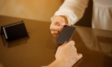 Elinde ziyaret kartı olan resepsiyonist kız. Kapatın. Resepsiyondaki hostes şirketin ya da otelin kartvizitini tutuyor. Logonuz için yer