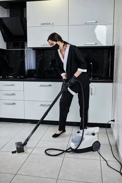 清洁服务公司员工使用专业的蒸汽清洗机 清除厨房地板上的污垢 — 图库照片