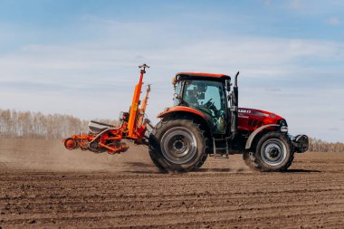 Vinnitsa, Ukrayna - 20 Nisan 2022: Bahar ekimi mevsimi. Traktörlü bir çiftçi tarlasına mısır tohumu ekiyor. İzli ekiciyle mısır ekiyorum. Çiftçilik tohumları