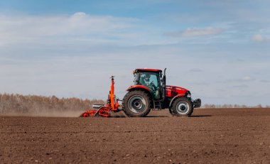 Vinnitsa, Ukrayna - 20 Nisan 2022: Bahar ekimi mevsimi. Traktörlü bir çiftçi tarlasına mısır tohumu ekiyor. İzli ekiciyle mısır ekiyorum. Çiftçilik tohumları