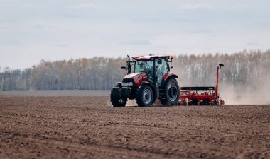 Vinnitsa, Ukrayna - 20 Nisan 2022: Bahar ekimi mevsimi. Traktörlü bir çiftçi tarlasına mısır tohumu ekiyor. İzli ekiciyle mısır ekiyorum. Çiftçilik tohumları