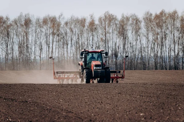 Vinnitsa, Ukrayna - 20 Nisan 2022: Bahar ekimi mevsimi. Traktörlü bir çiftçi tarlasına mısır tohumu ekiyor. İzli ekiciyle mısır ekiyorum. Çiftçilik tohumları