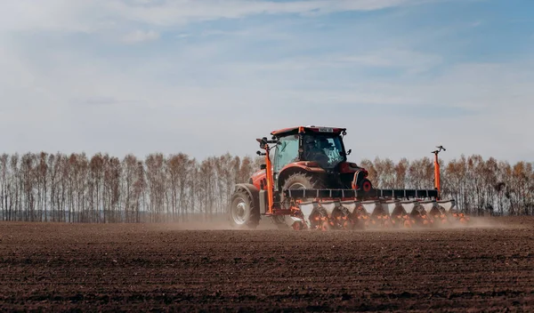 Vinnitsa, Ukrayna - 20 Nisan 2022: Bahar ekimi mevsimi. Traktörlü bir çiftçi tarlasına mısır tohumu ekiyor. İzli ekiciyle mısır ekiyorum. Çiftçilik tohumları