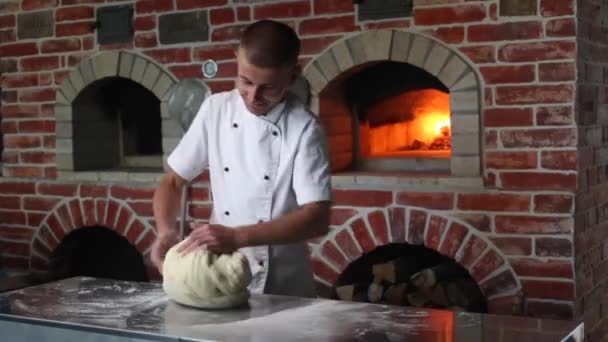主厨在厨房的一个烧木柴的烤箱旁 用面粉揉碎面团 烹调意大利披萨 — 图库视频影像