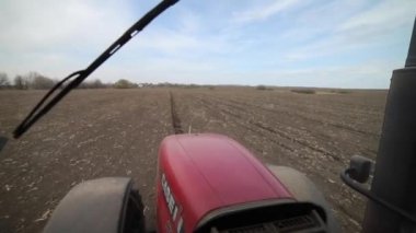 Vinnitsa, Ukrayna - 20 Nisan 2022: Bahar ekimi mevsimi. Traktörlü bir çiftçi tarlasına mısır tohumu ekiyor. İzli ekiciyle mısır ekiyorum. Çiftçilik tohumları. 