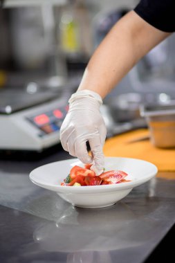 Taze hazırlanmış Yunan salatasını beyaz tabakta tutuyor. Vejetaryen salatası arayışı.