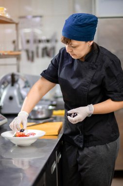 Mutfakta şef bir salatalık keser ve bir Yunan salatası hazırlar. Vejetaryen salatası arayışı.