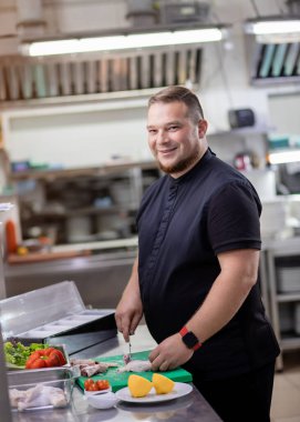 Şef tavuk leşini keser ve marine etmek için hazırlar.