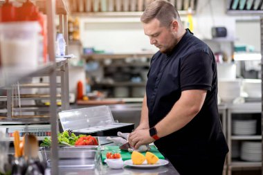 Şef tavuk leşini keser ve marine etmek için hazırlar.