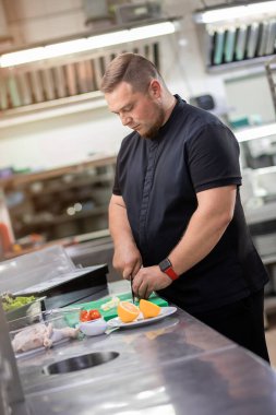 Mutfaktaki şef tavuk yemeği hazırlamak için taze soğan kesiyor.