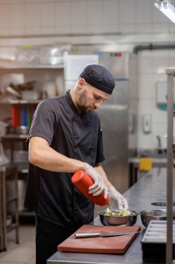 Şef ızgara için sebze marine eder.