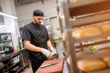 Şef ızgara için sebze marine eder.