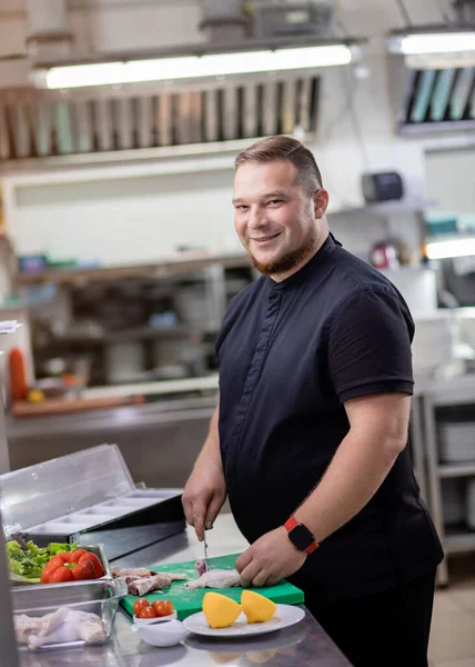 Şef tavuk leşini keser ve marine etmek için hazırlar.