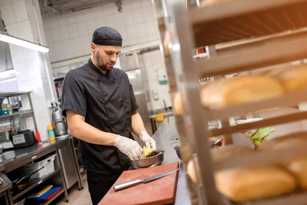 Şef ızgara için sebze marine eder.